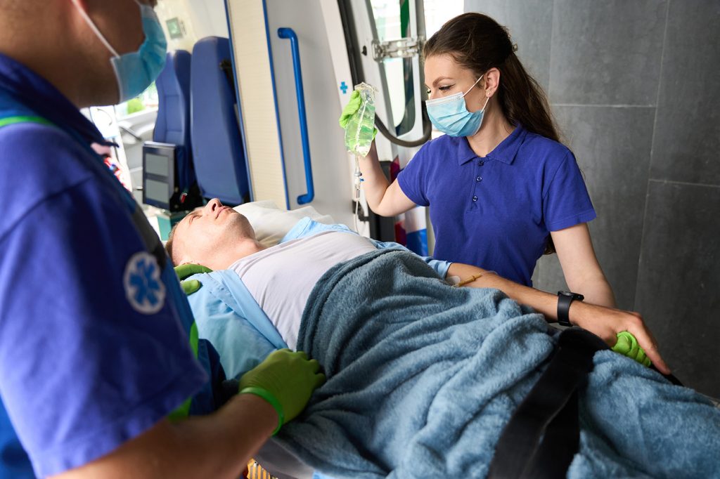 Patient on special gurney is moved from ambulance